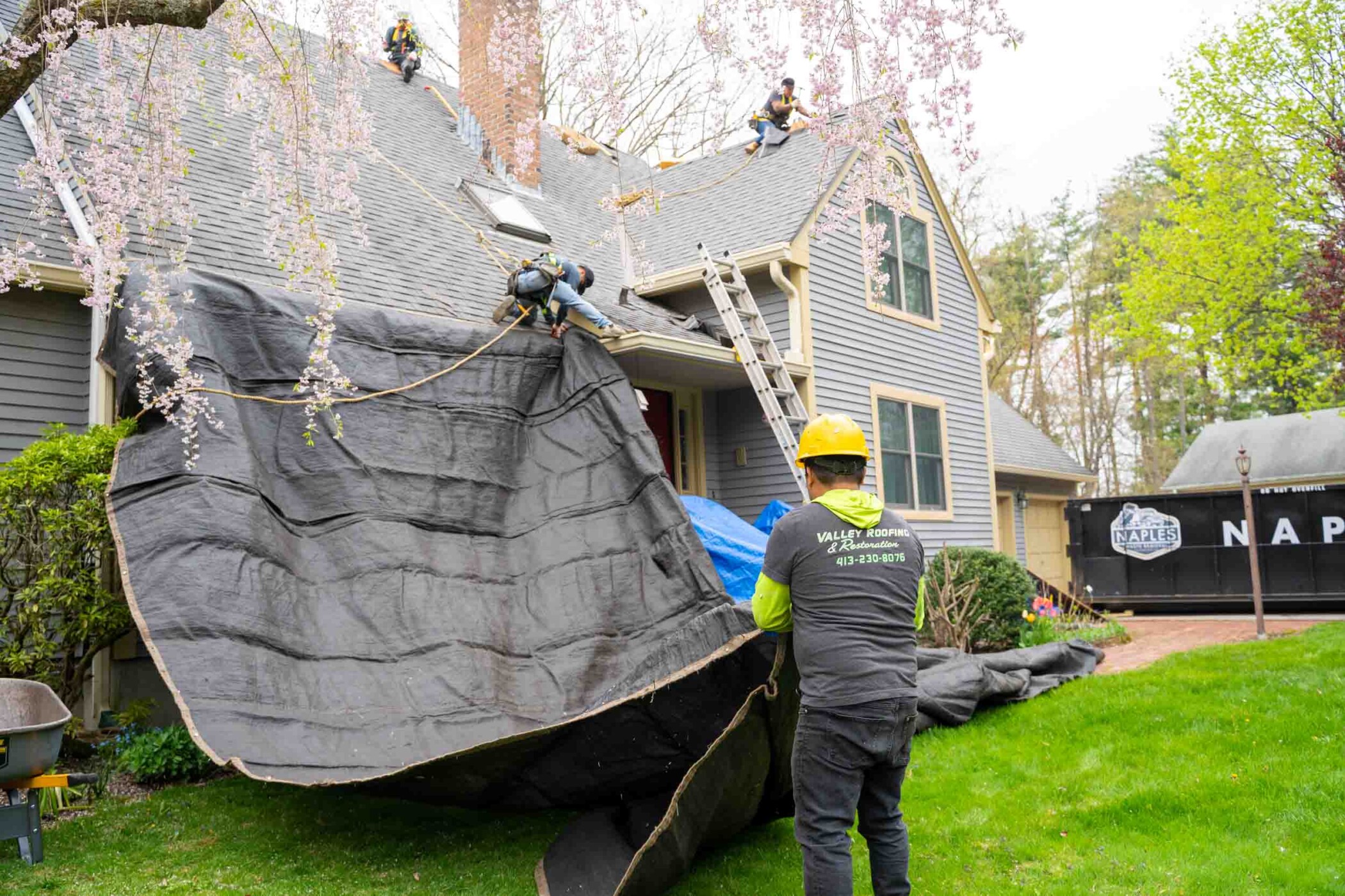 Valley Roofing and Restoration worker installing roof and tarp