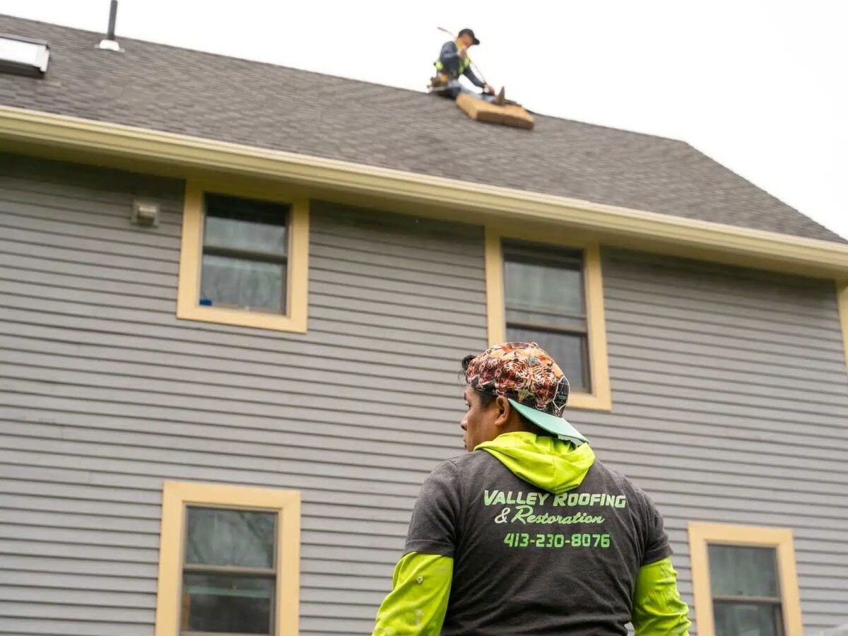 Valley Roofing and Restoration worker standing in font of house