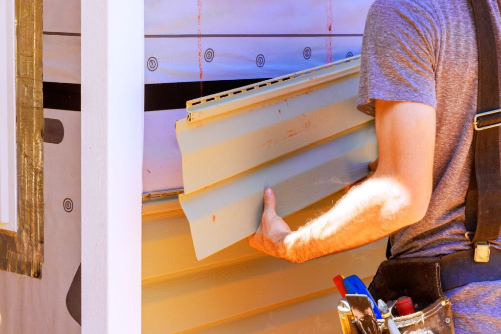 worker installing siding using uniform